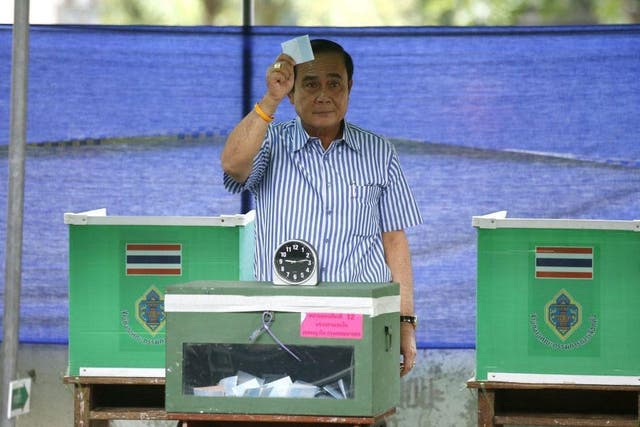 Thai Prime Minister Prayut Chan-o-cha casts his ballot during a referendum for the new constitution at a polling station in Bangkok