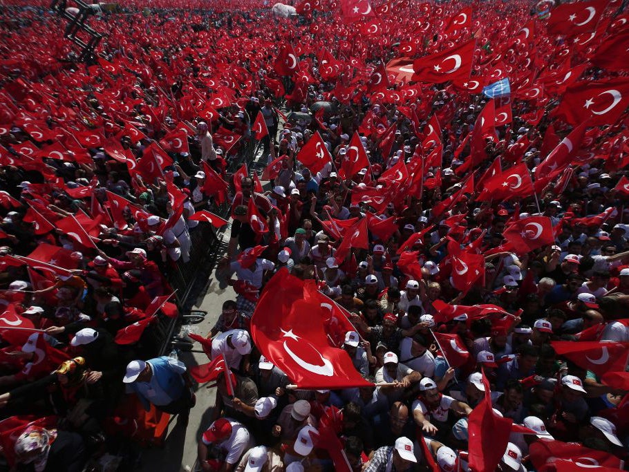 People wave Turkish flags during a rally to protest the failed coup attempt