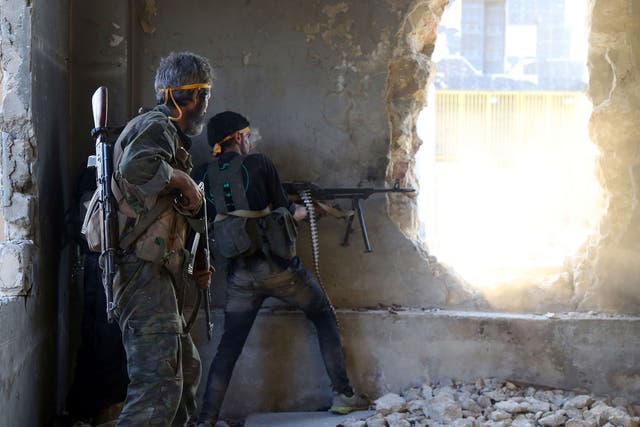 Rebel fighters fire towards regime forces positions on the outskirts of Aleppo