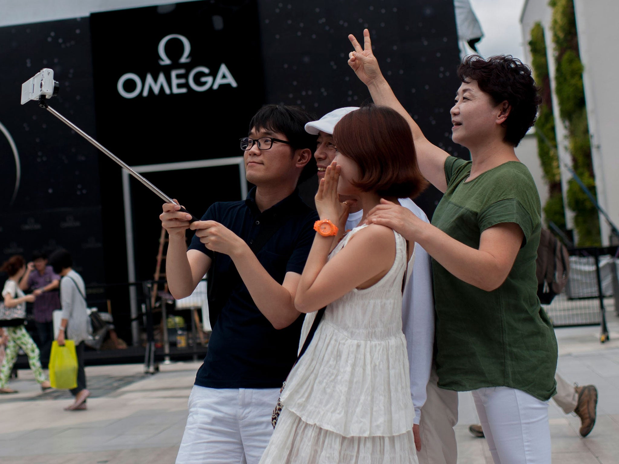 Tourists take a picture with a selfie stick at Siam on August 29, 2014 in Bangkok, Thailand.