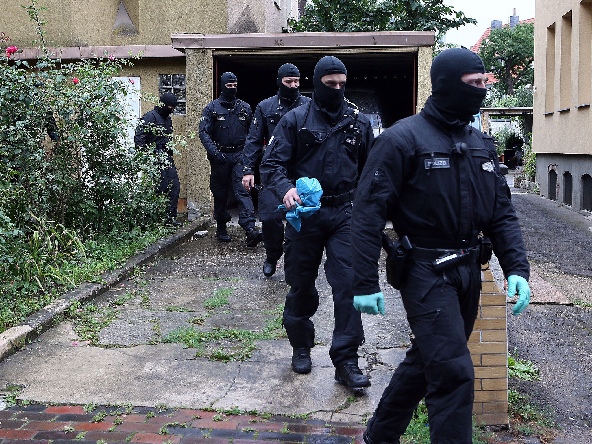 Masked police forces leave after searching a house in Hildesheim, Germany, 10 August 2016.