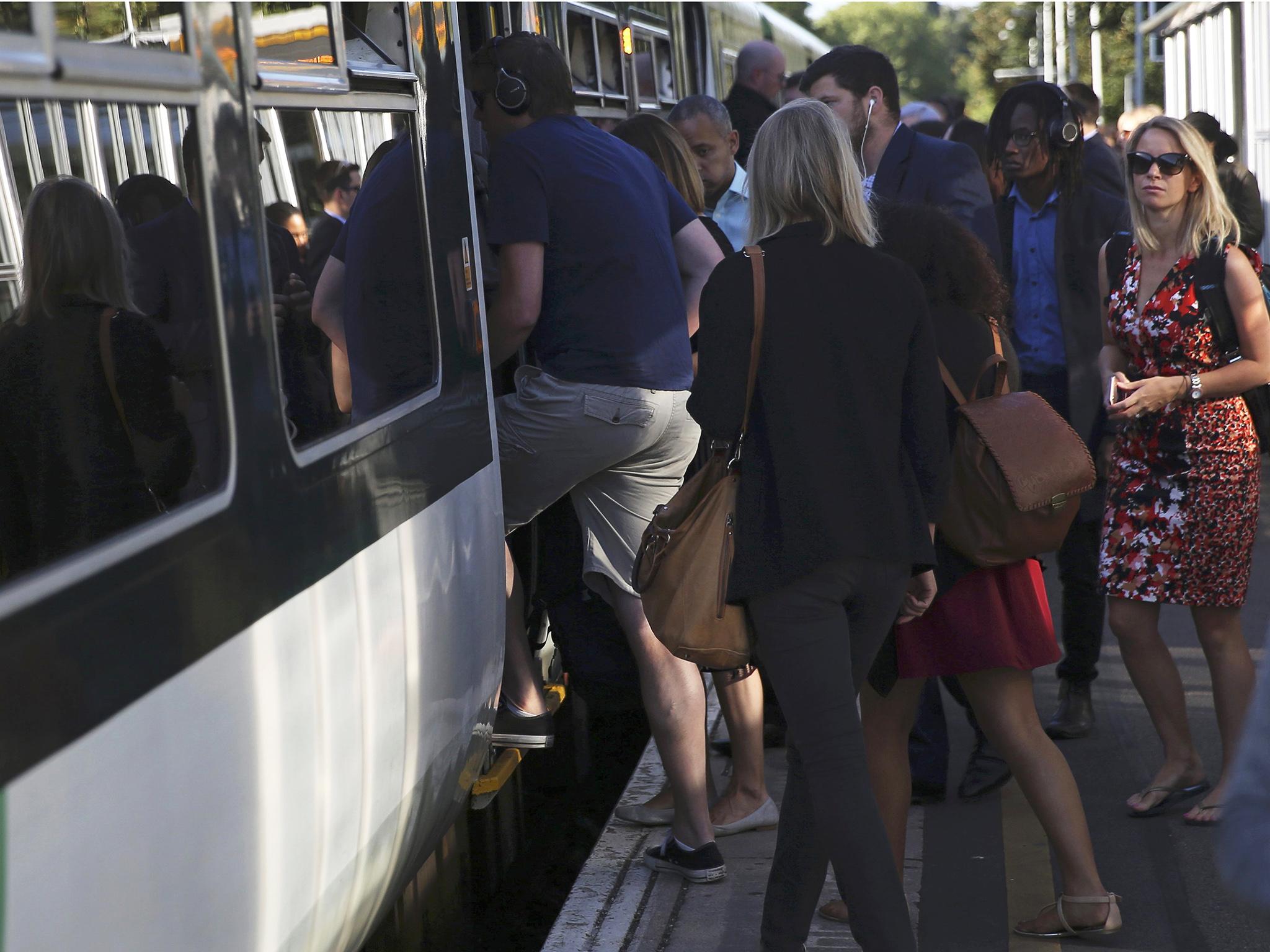 Passengers board a Southern train at Dulwich East station in London, Britain