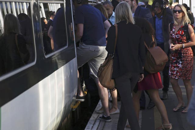 Passengers board a Southern train at Dulwich East station in London, Britain