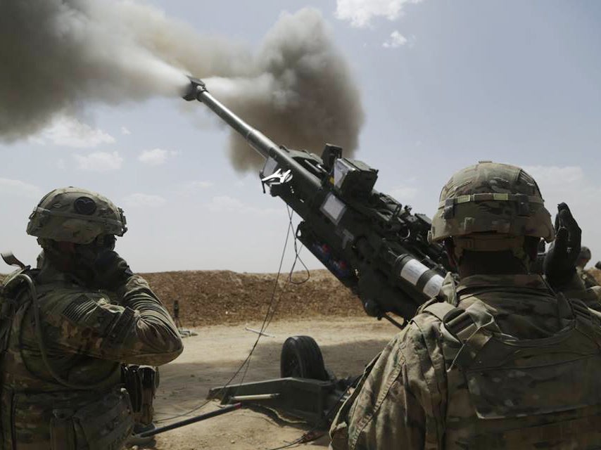 In this May 23, 2016 photo released by the US army, soldiers fire an M777 howitzer at Kara Soar Base, Iraq
