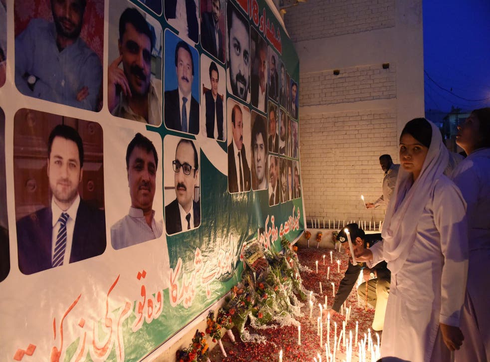 Pakistani nurses place candles at the site during a vigil to pay tribute