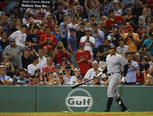 Fans stand to take pictures as Alex Rodriguez prepares to bat during one of his final games for the New York Yankees