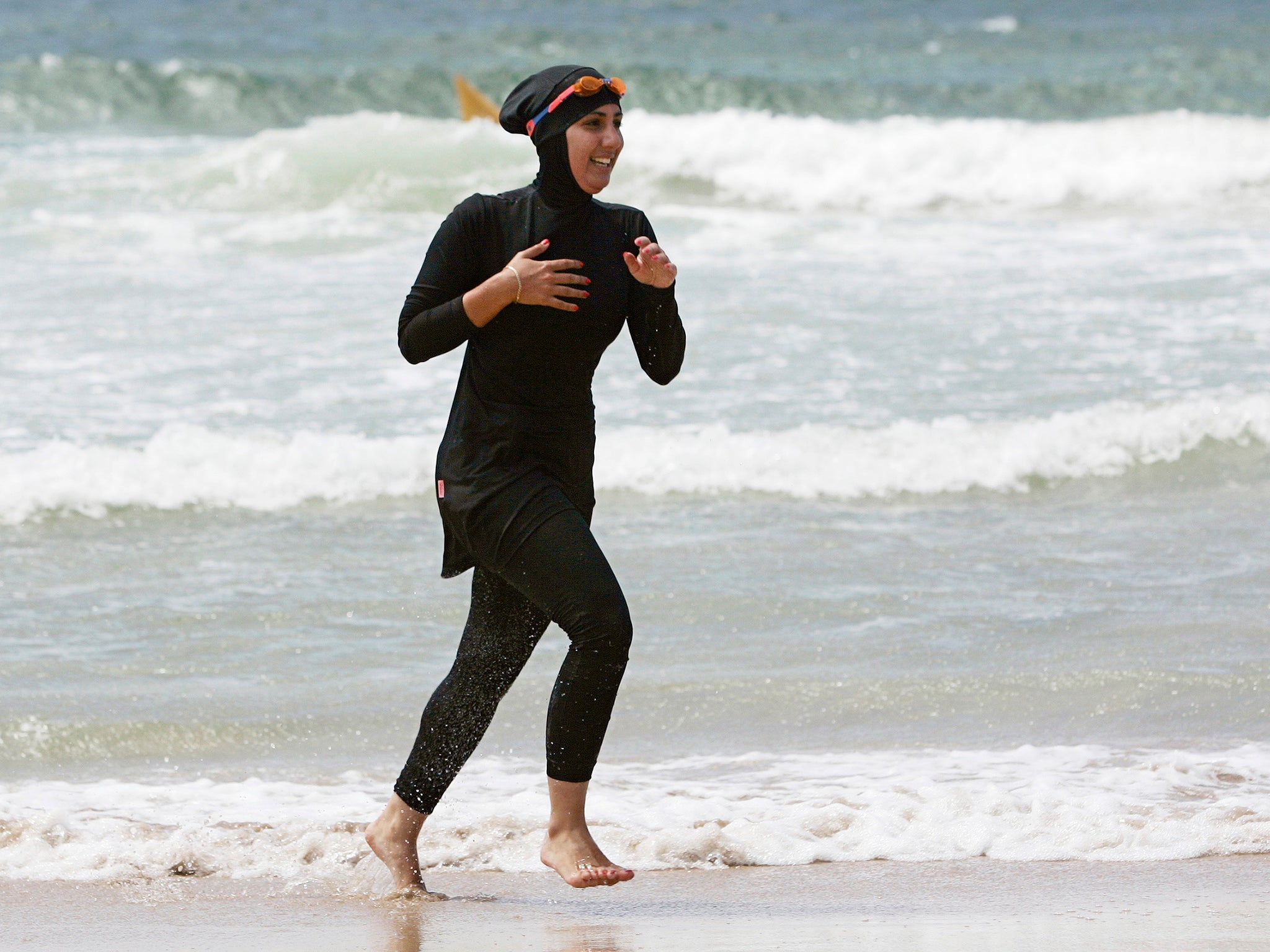 Volunteer surf life saver Mecca Laalaa runs along a beach in Sydney, 2007