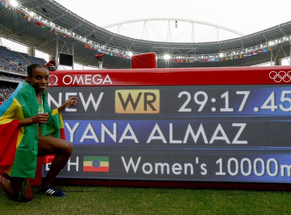 Almaz poses next to her new women's 10,000m world record