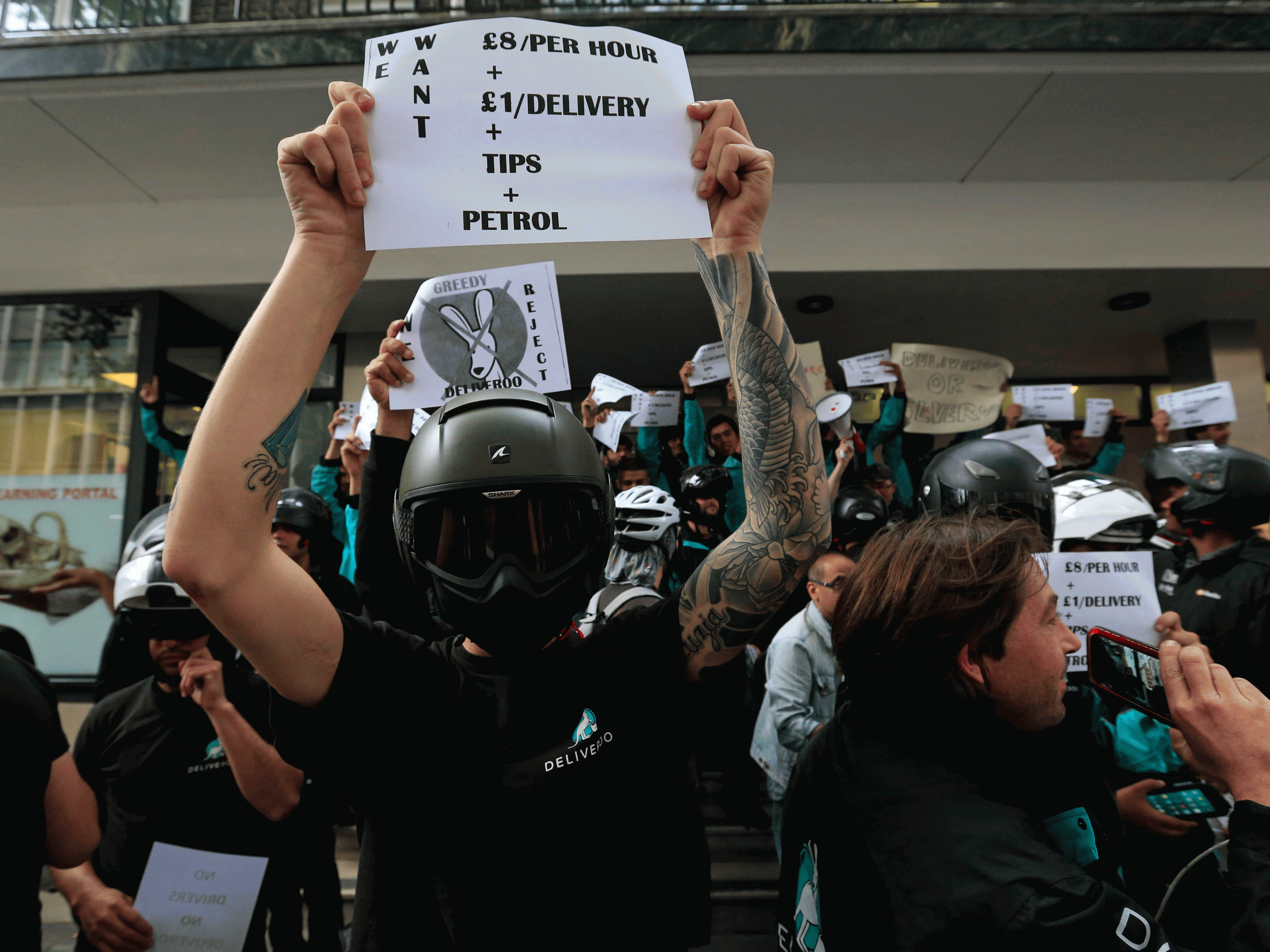 Deliveroo riders hold a protest over pay outside the company HQ in London on Thursday