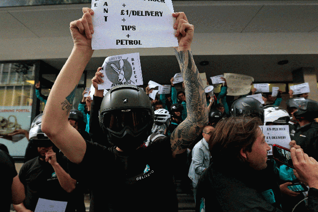 Deliveroo riders hold a protest over pay outside the company HQ in London on Thursday