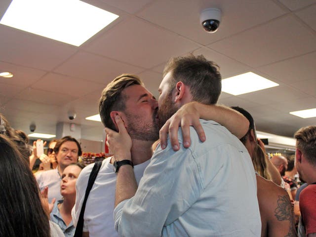Thomas Rees and Joshua Bradwell kiss inside the store days after they were told to leave for holding hands.