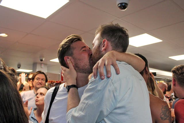 Thomas Rees and Joshua Bradwell kiss inside the store days after they were told to leave for holding hands.