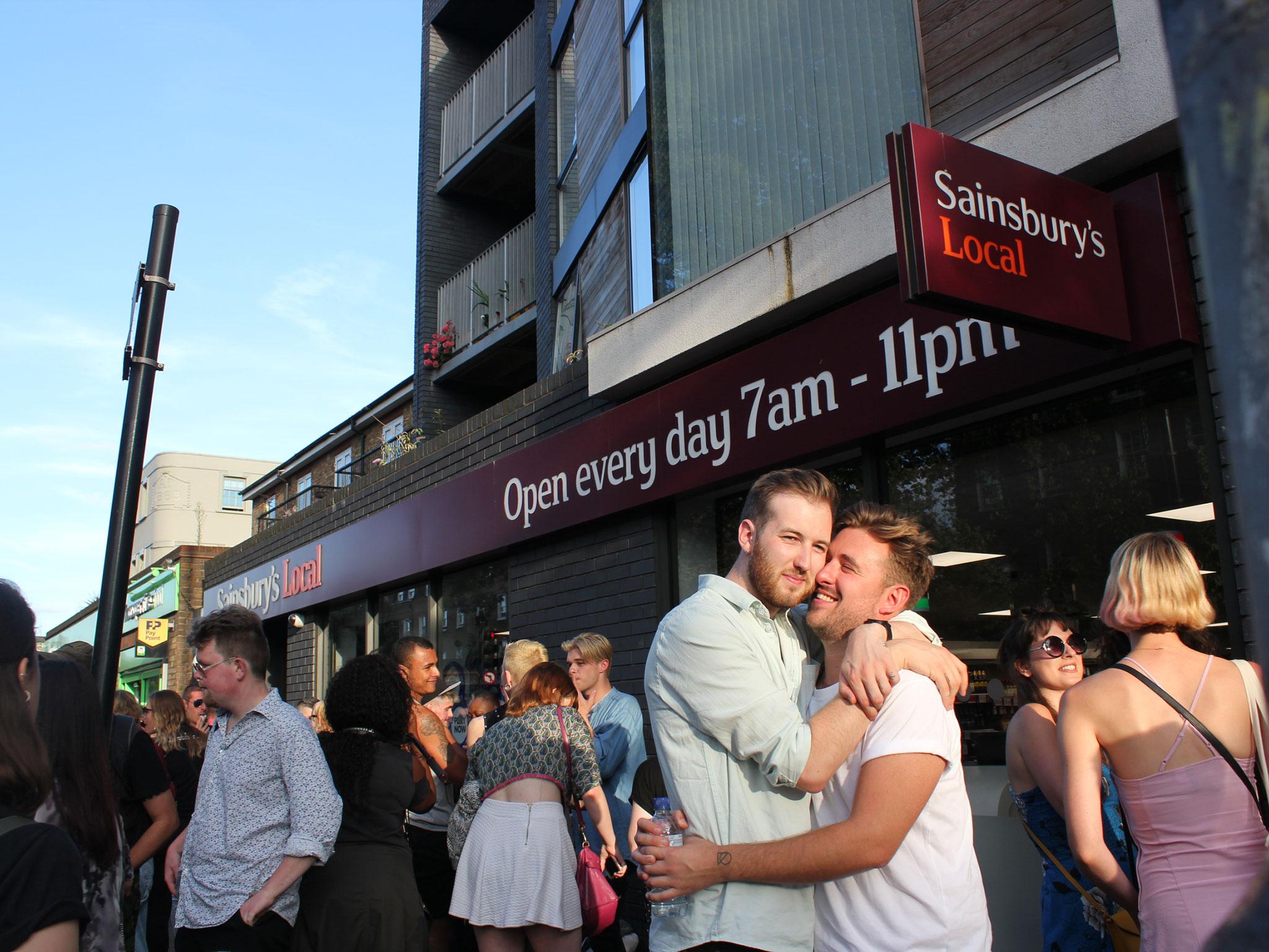 Josh Bradwell (L) and Thomas Rees embrace outside the Sainsbury's where they were told to leave for holding hands