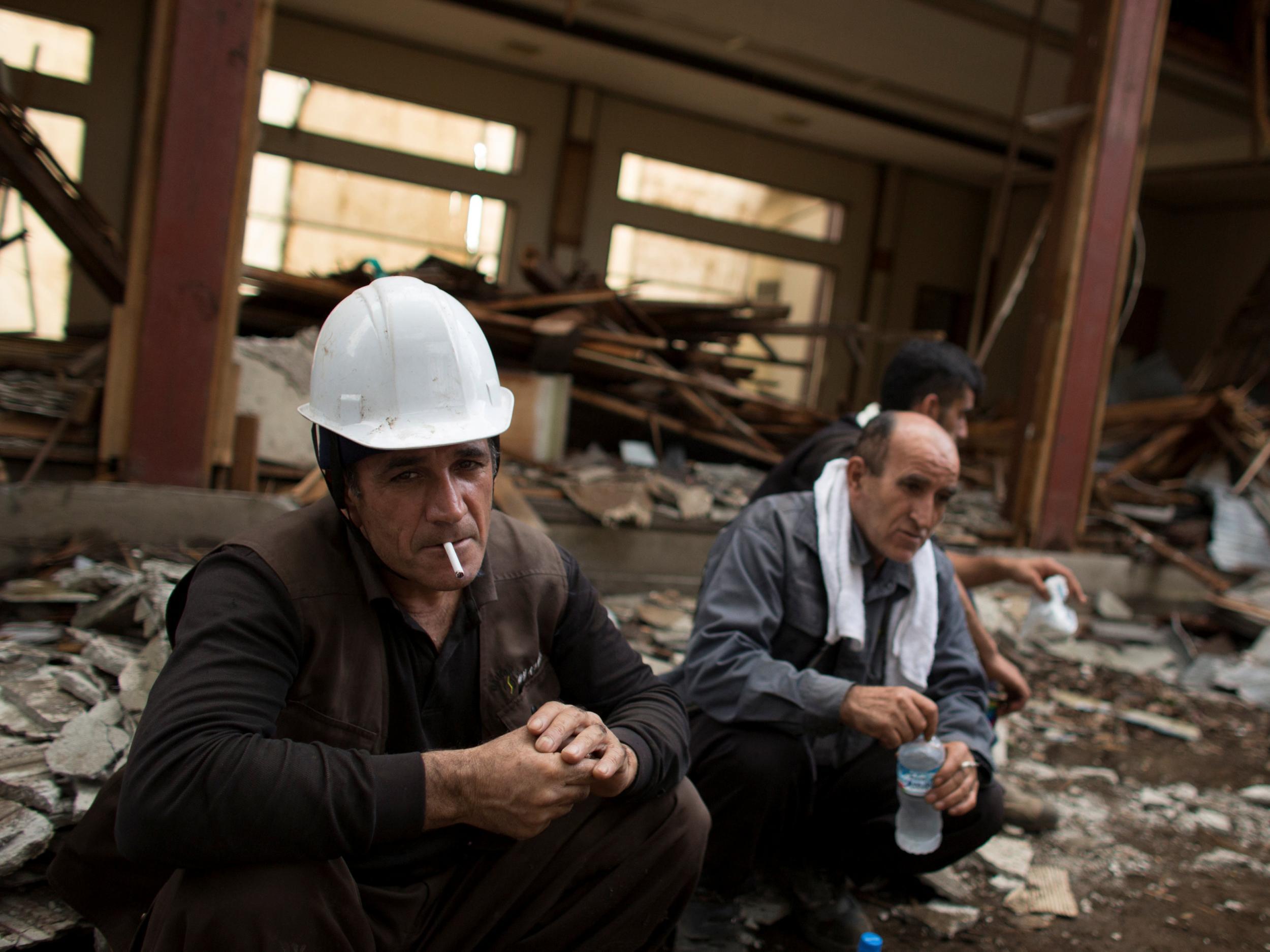 Kurdish worker Suleyman Hasgul smokes a cigarette during a break at a demolition site in Chiba east of Tokyo