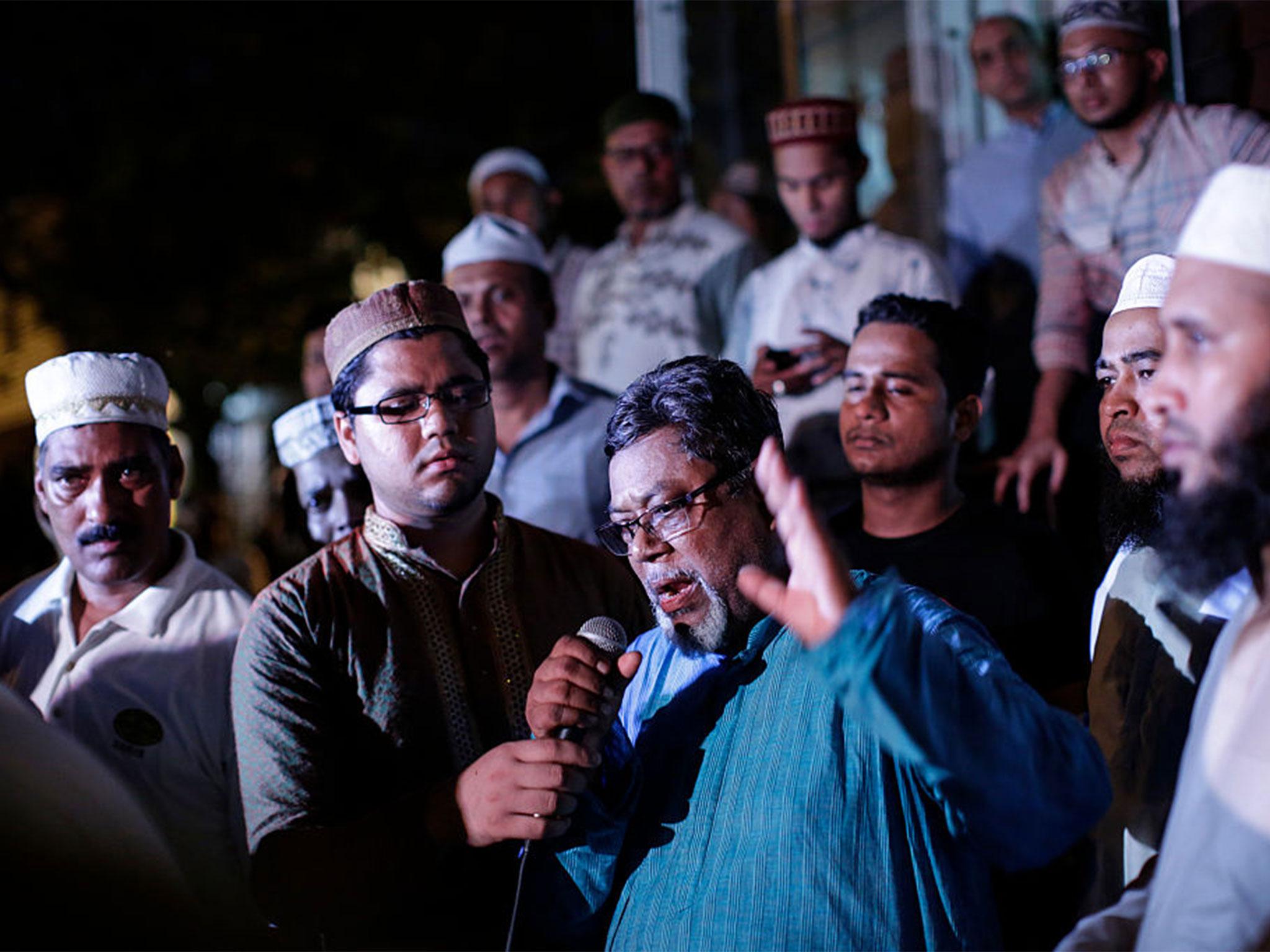 Community members pray outside the Al-Furqan Jame Mosque in Ozone Park after imam Maulama Akonjee and friend Thara Uddin were killed