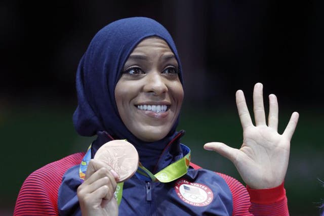 Ibtihaj Muhammad of the United States pose with her bronze medals on the podium after the womens team sabre fencing event