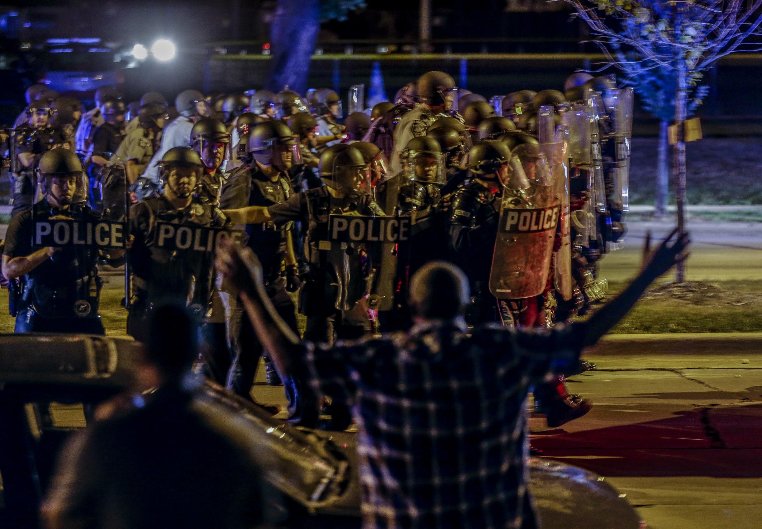 Police move in on a group of protesters throwing rocks in Milwaukee during a second night of protests at the police killing of a black man