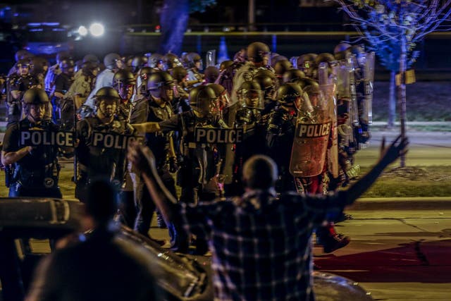Police move in on a group of protesters throwing rocks in Milwaukee during a second night of protests at the police killing of a black man