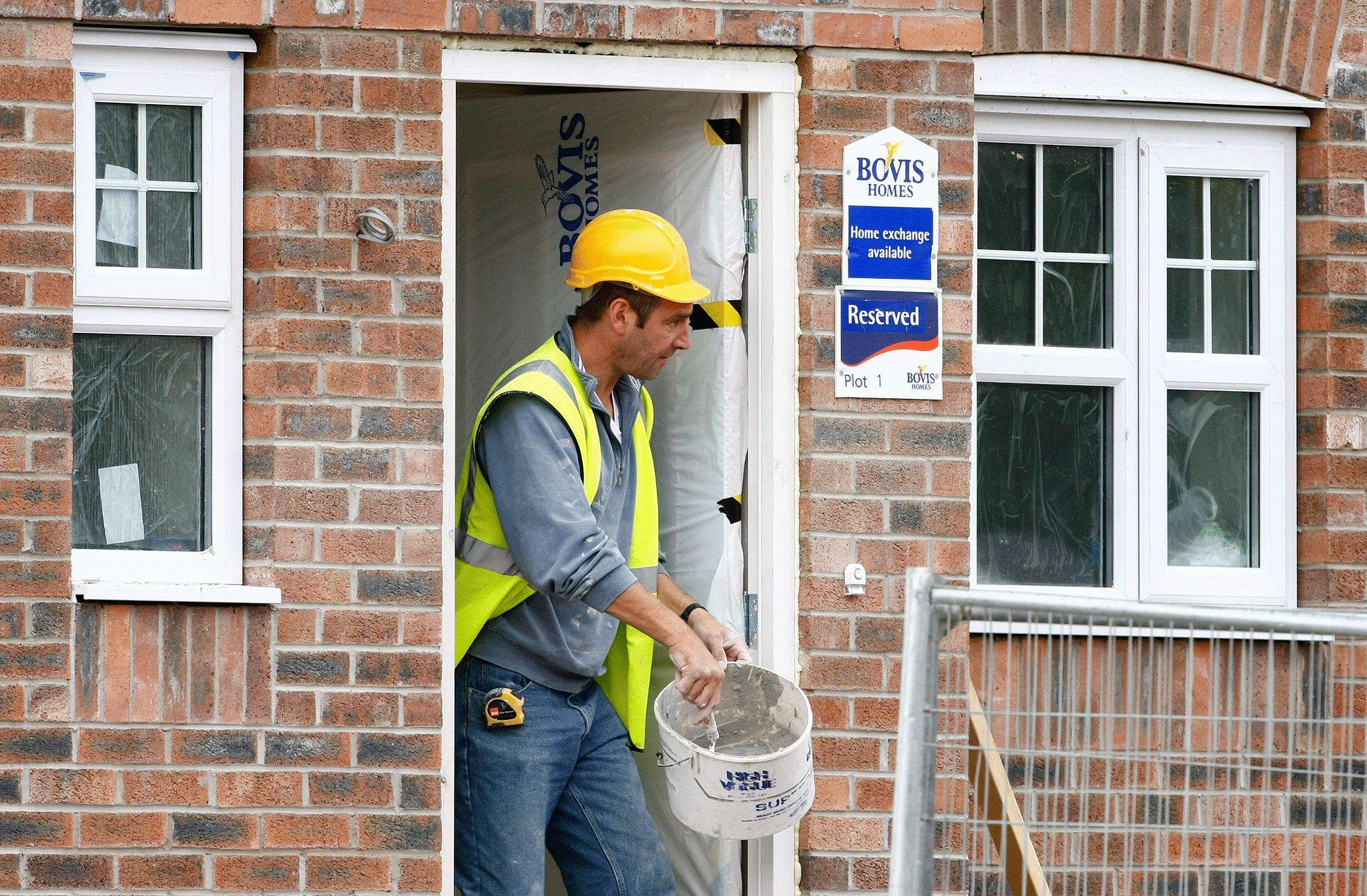 A builder works on a Bovis housing development near Bolton