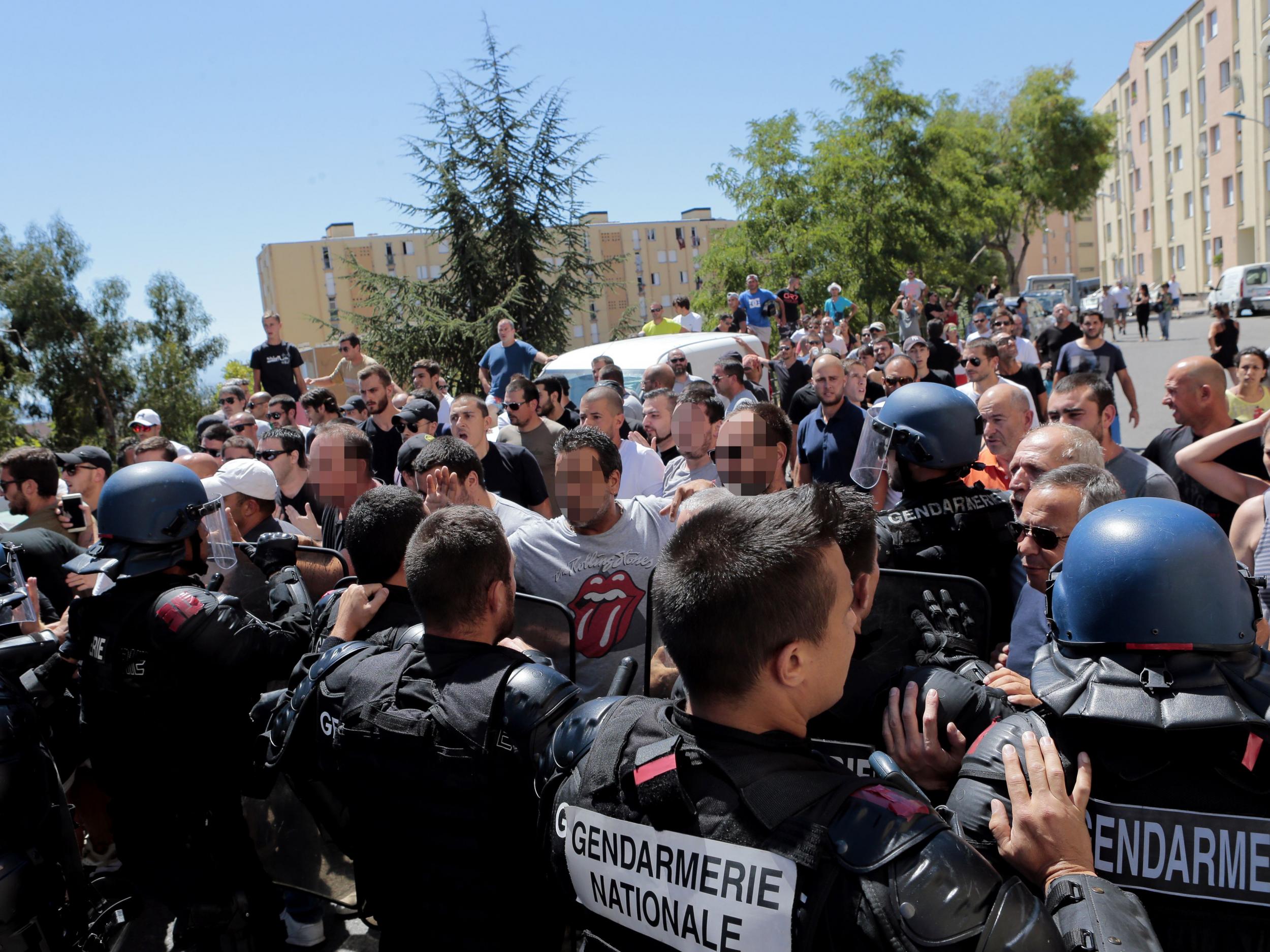 Hundreds walk into the cite des Monts surrounded by policemen in Lupino on August 14, 2016 in Bastia on the French Mediterranean island of Corsica