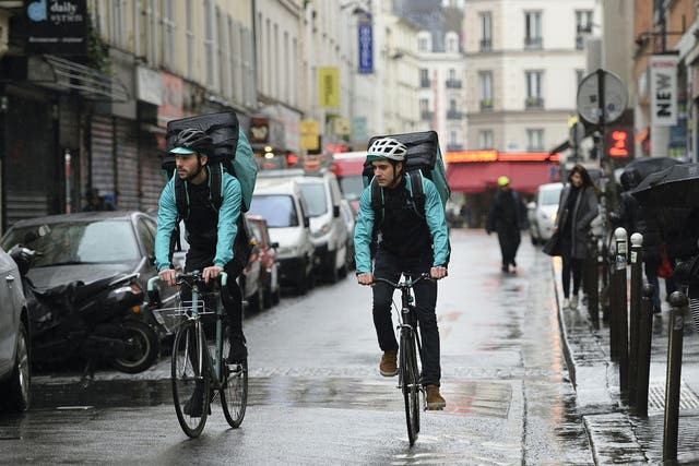 Deliveroo riders wearing company livery at work 