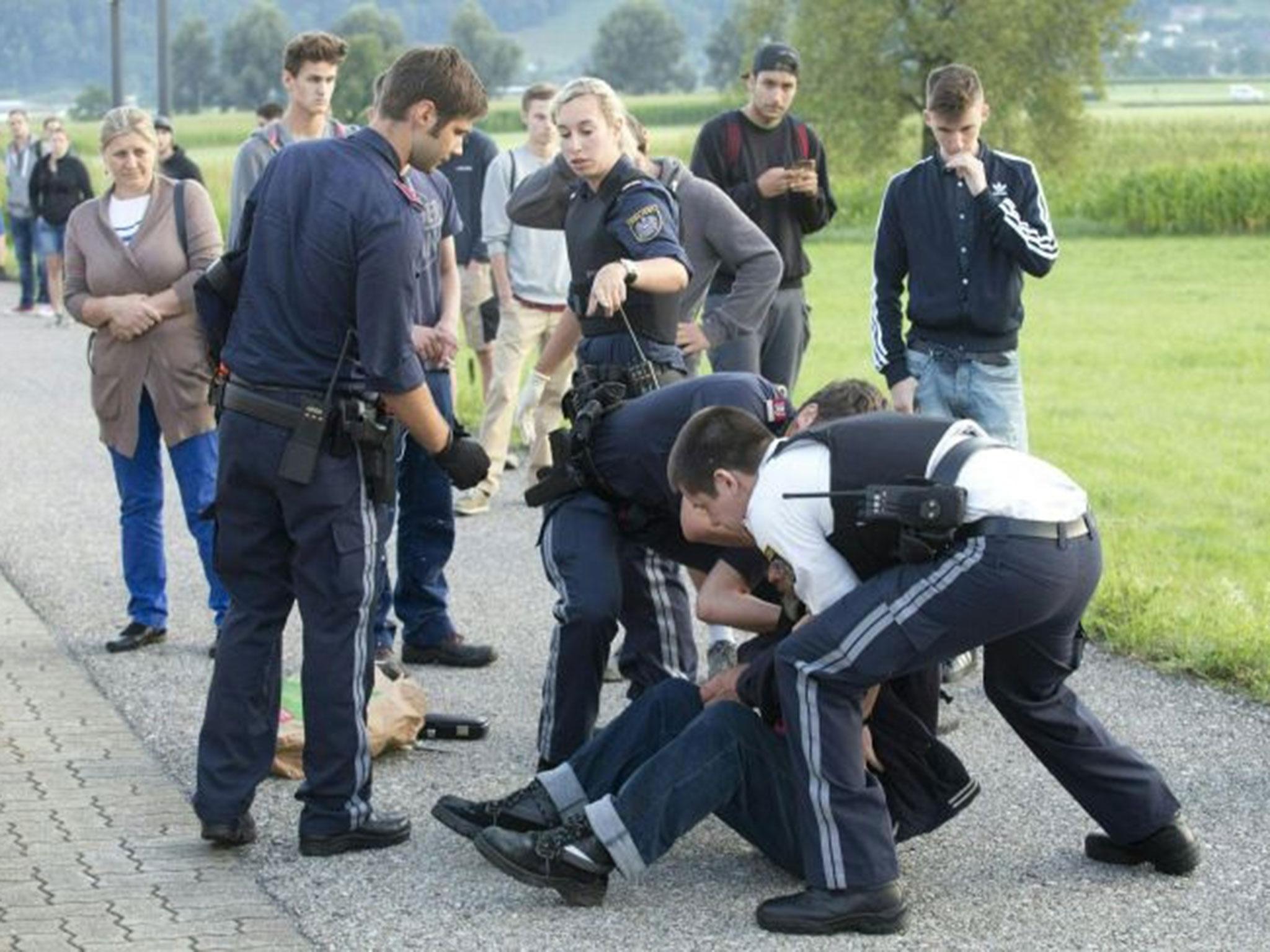 Austrian policemen arrest a suspect on 16 August, 2016 at the train station near the village of Sulz, in Vorarlberg, Austria, after he had attacked two train passengers with a knife