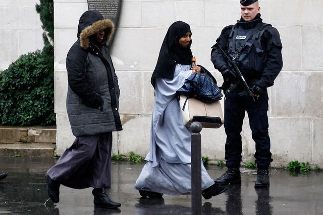 A French police officer stands guard as Muslim women leave the Great Mosque of Paris (Grande mosquee de Paris) after the Friday prayers on November 20, 2015 in Paris, France.
