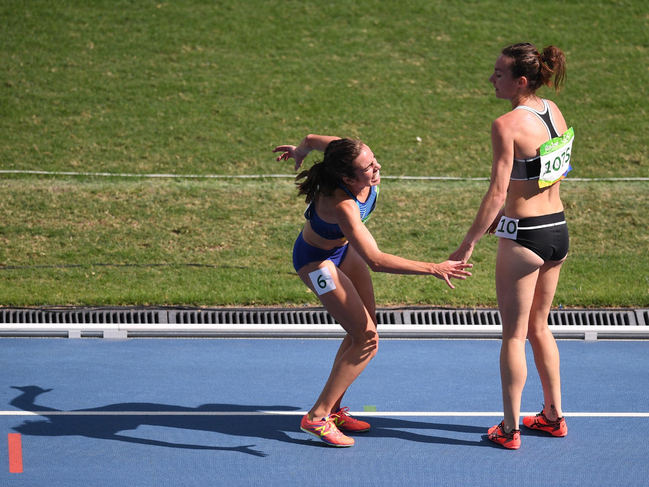 New Zealand's Nikki Hamblin (R) helps USA's Abbey D'Agostino after she was injured in the Women's 5000m Round 1