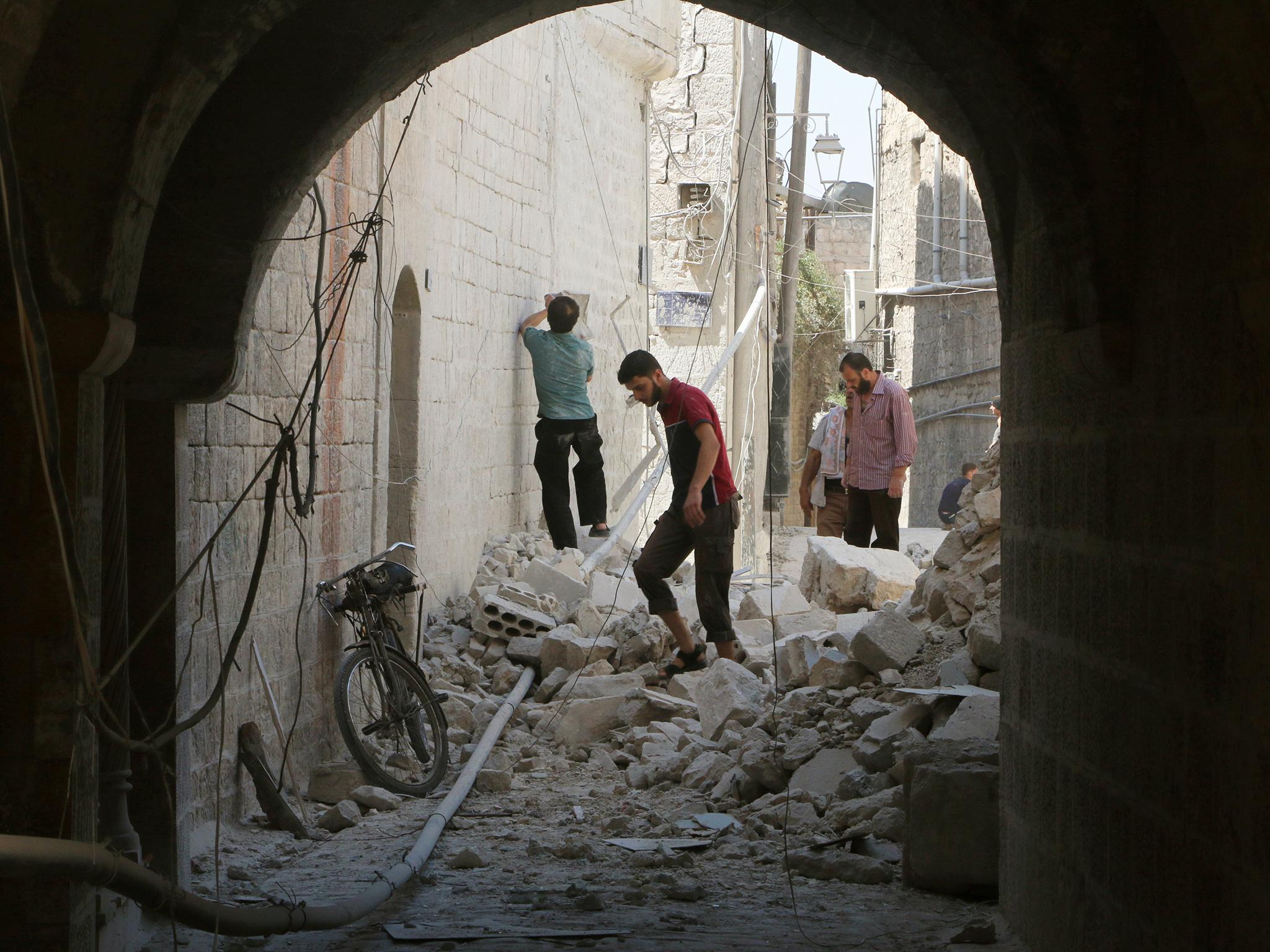 Residents inspect their damaged homes after an air strike on the rebel-held Old Aleppo on Monday