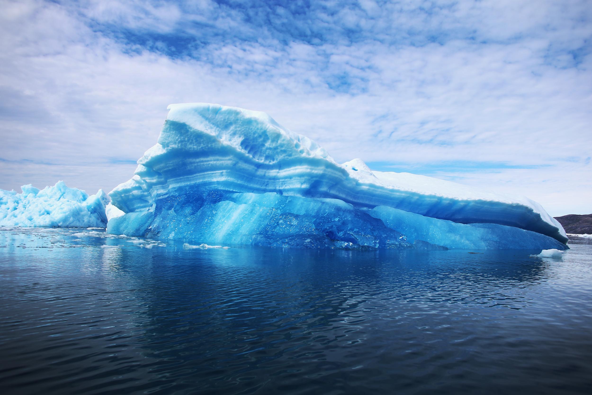 The tightly packed ice of Arctic icebergs thoroughly absorbs blue light, making them appear blue