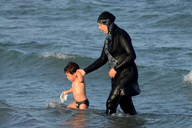A woman wears a burkini in the sea