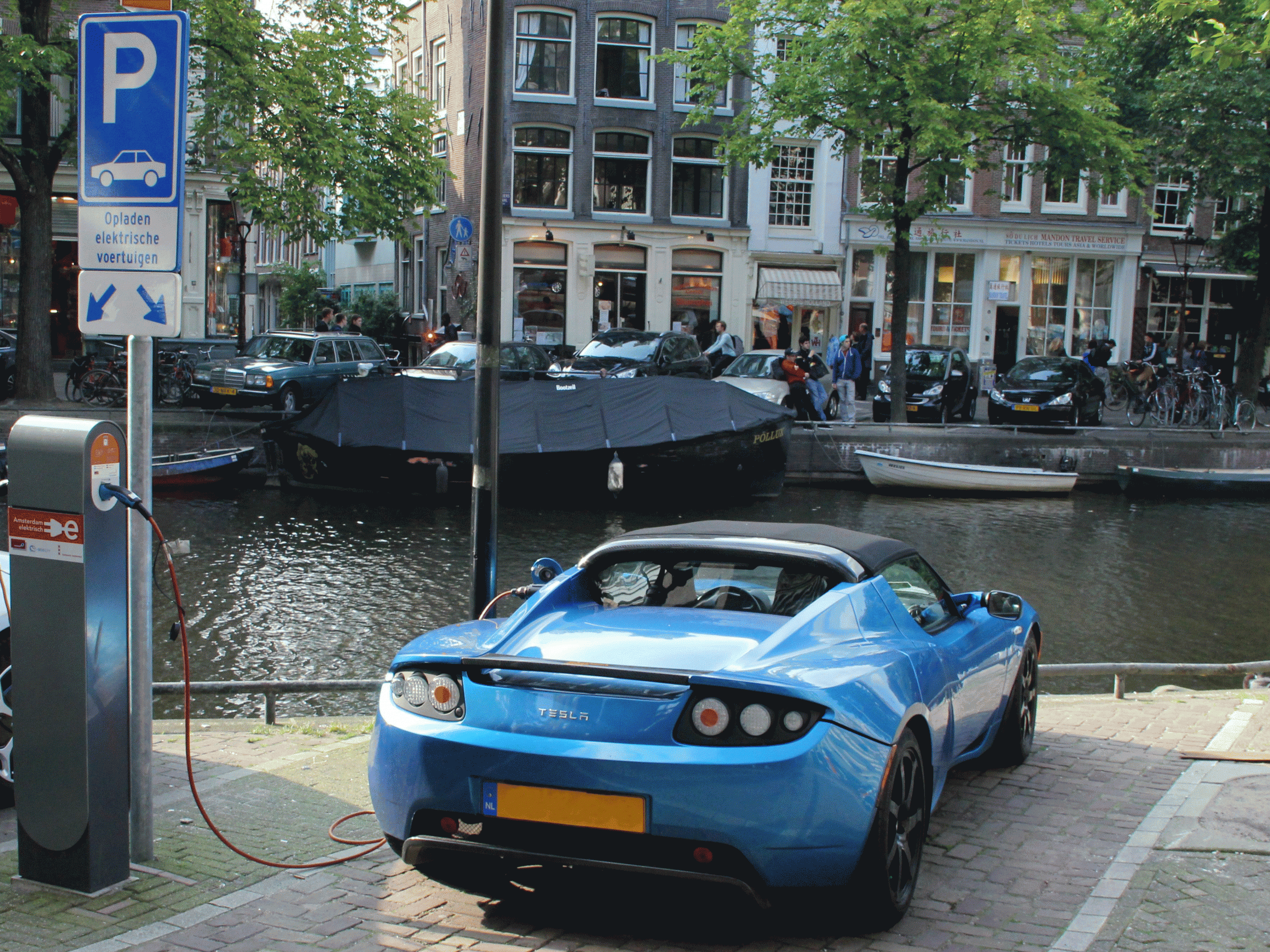 An electric Tesla car recharges on the banks of a canal in Amsterdam. The Netherlands saw an all-time high in electric cars in December this year
