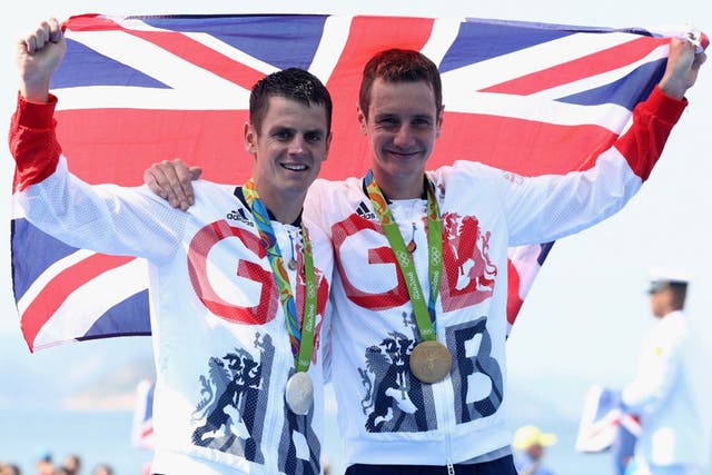 <p>Gold medalist  Alistair Brownlee (right) and silver medalist Jonathan Brownlee of Great Britain celebrate on the podium after the Men's Triathlon</p>