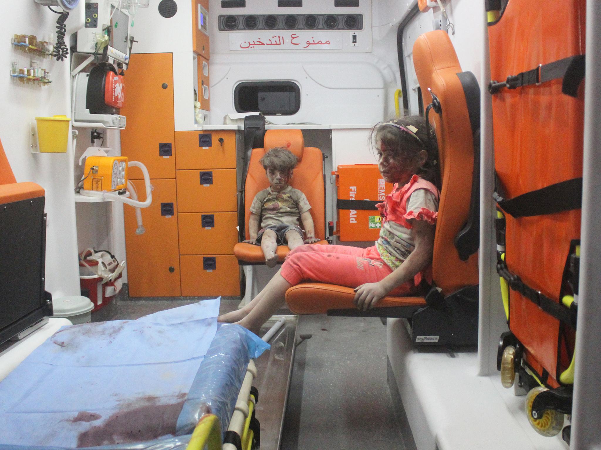 Five-year-old Omran Daqneesh, with bloodied face, sits with his sister inside an ambulance after an airstrike in Aleppo
