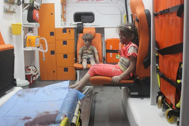Five-year-old Omran Daqneesh, with bloodied face, sits with his sister inside an ambulance after they were rescued following an airstrike in the rebel-held al-Qaterji neighbourhood of Aleppo