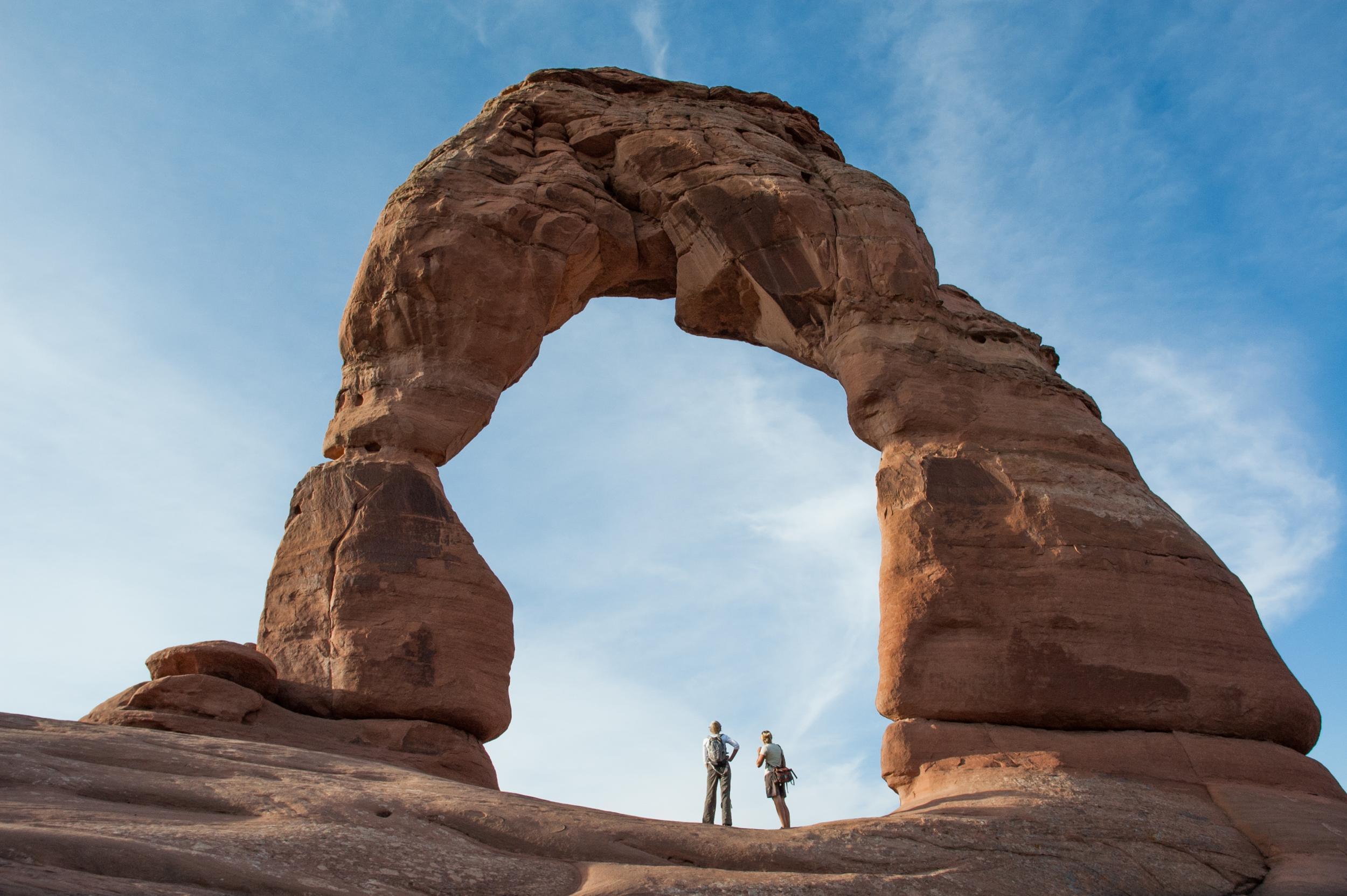 Hikers stand beneath Utah's most recognised landmark, Delicate Arch