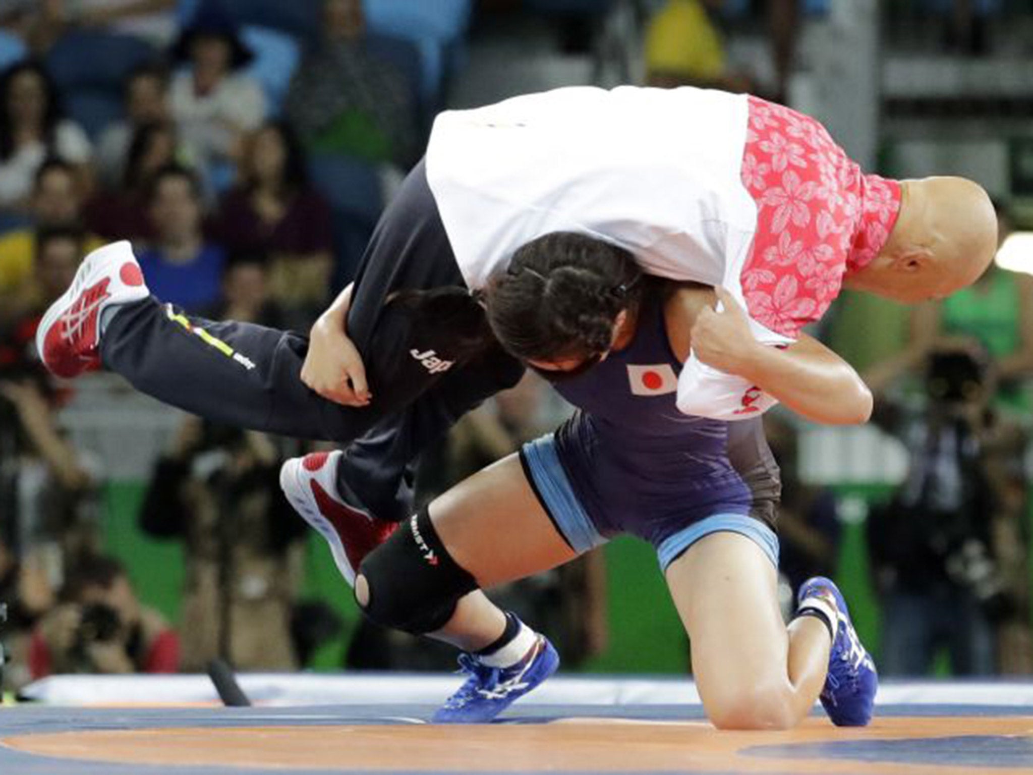 Japan's gold medal-winning wrestler Risako Kiwai slams her coach, Kazuhito Sakae, onto the mat in celebration