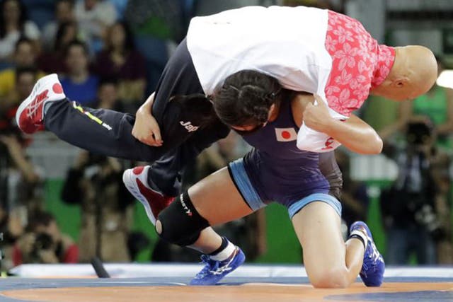 Japan's gold medal-winning wrestler Risako Kiwai slams her coach, Kazuhito Sakae, onto the mat in celebration