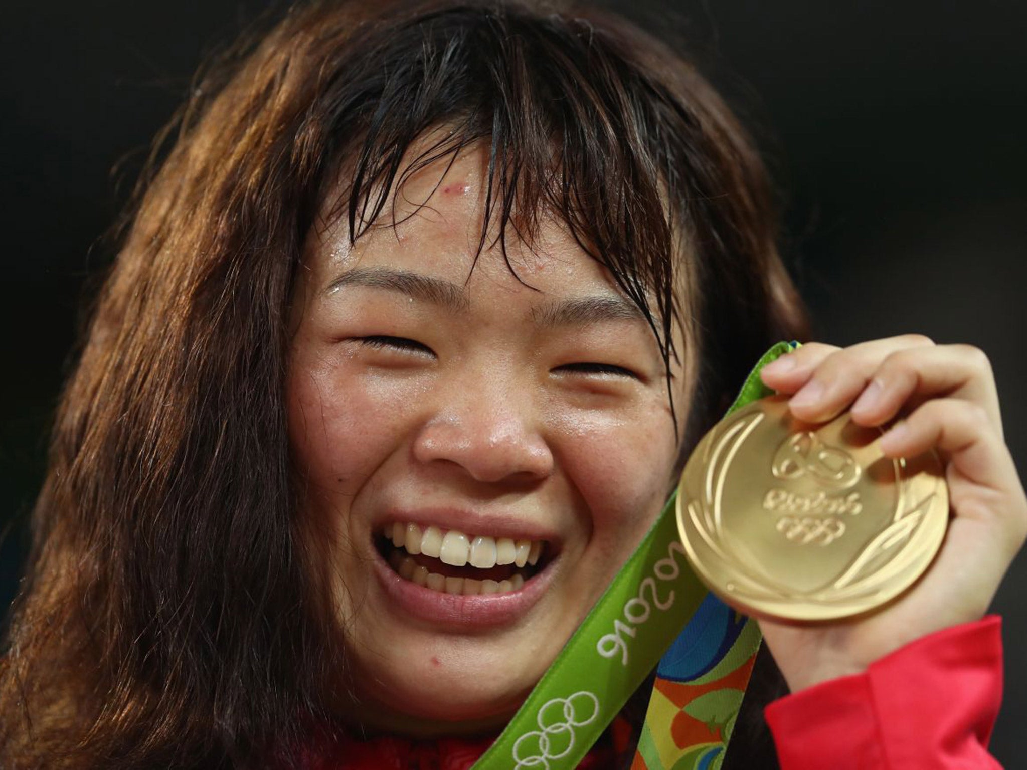 Risako Kawai celebrates with her gold medal for winning the women's 63kg wrestling class