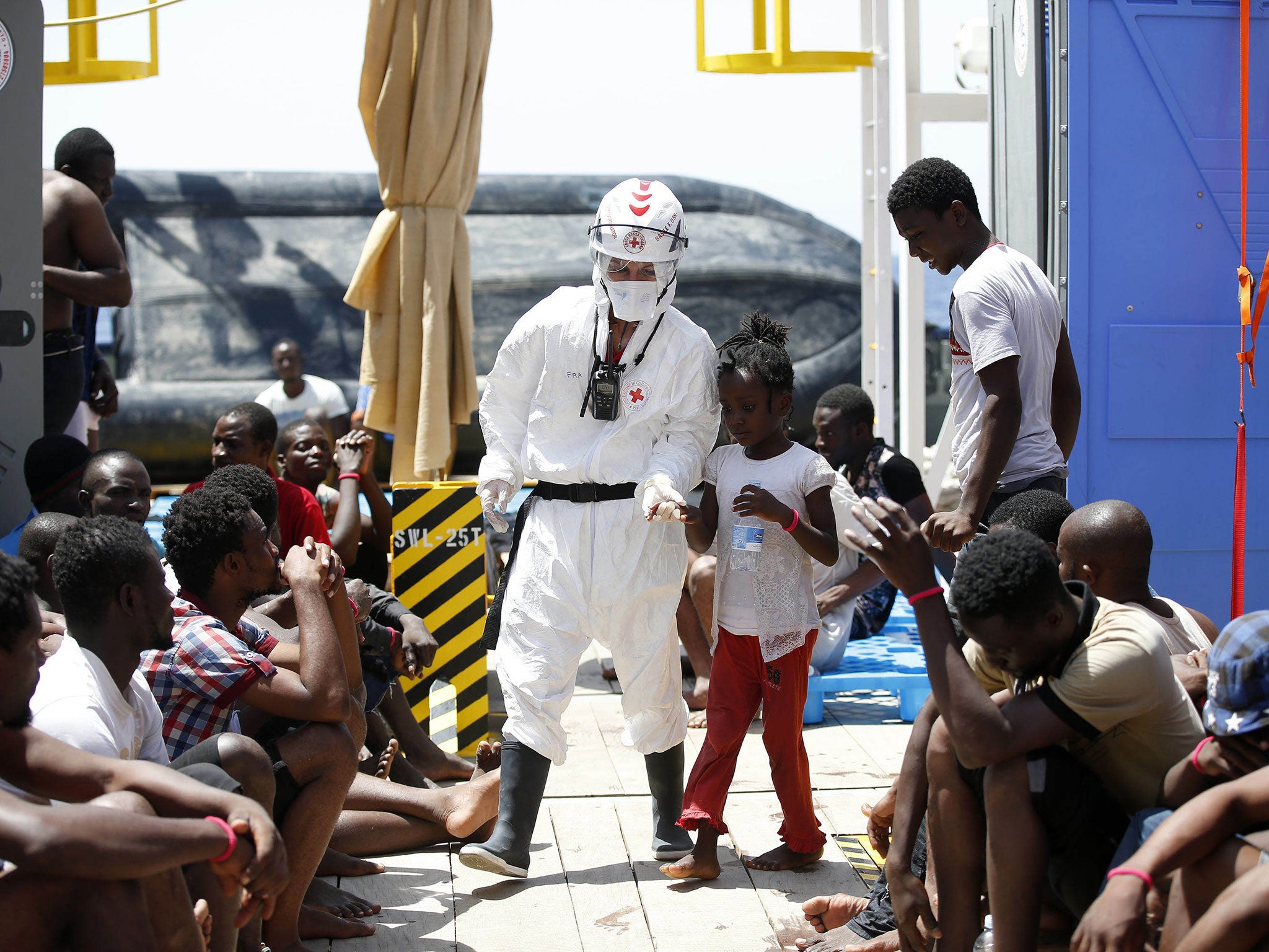 A Red Cross worker with child refugees in Sicily after a rescue operation on Thursday