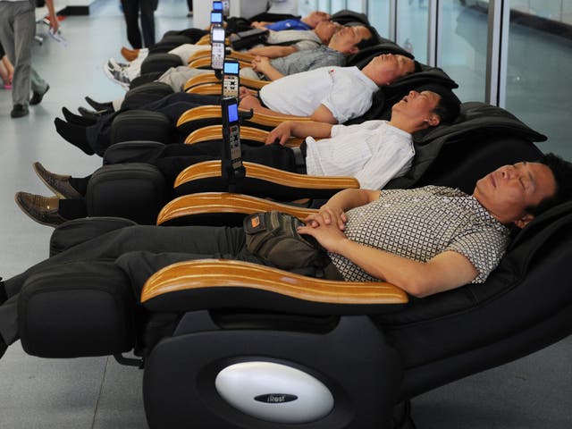 Passengers sleep in massage chairs in Yichang Sanxia airport in central China