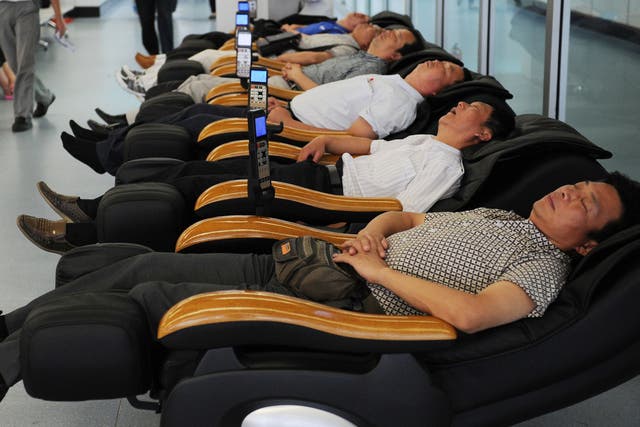 Passengers sleep in massage chairs in Yichang Sanxia airport in central China