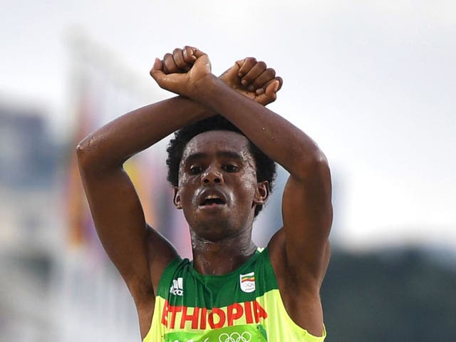 Feyisa Lilesa holding up his arms above his head in an X as a tribute to the Oromo people