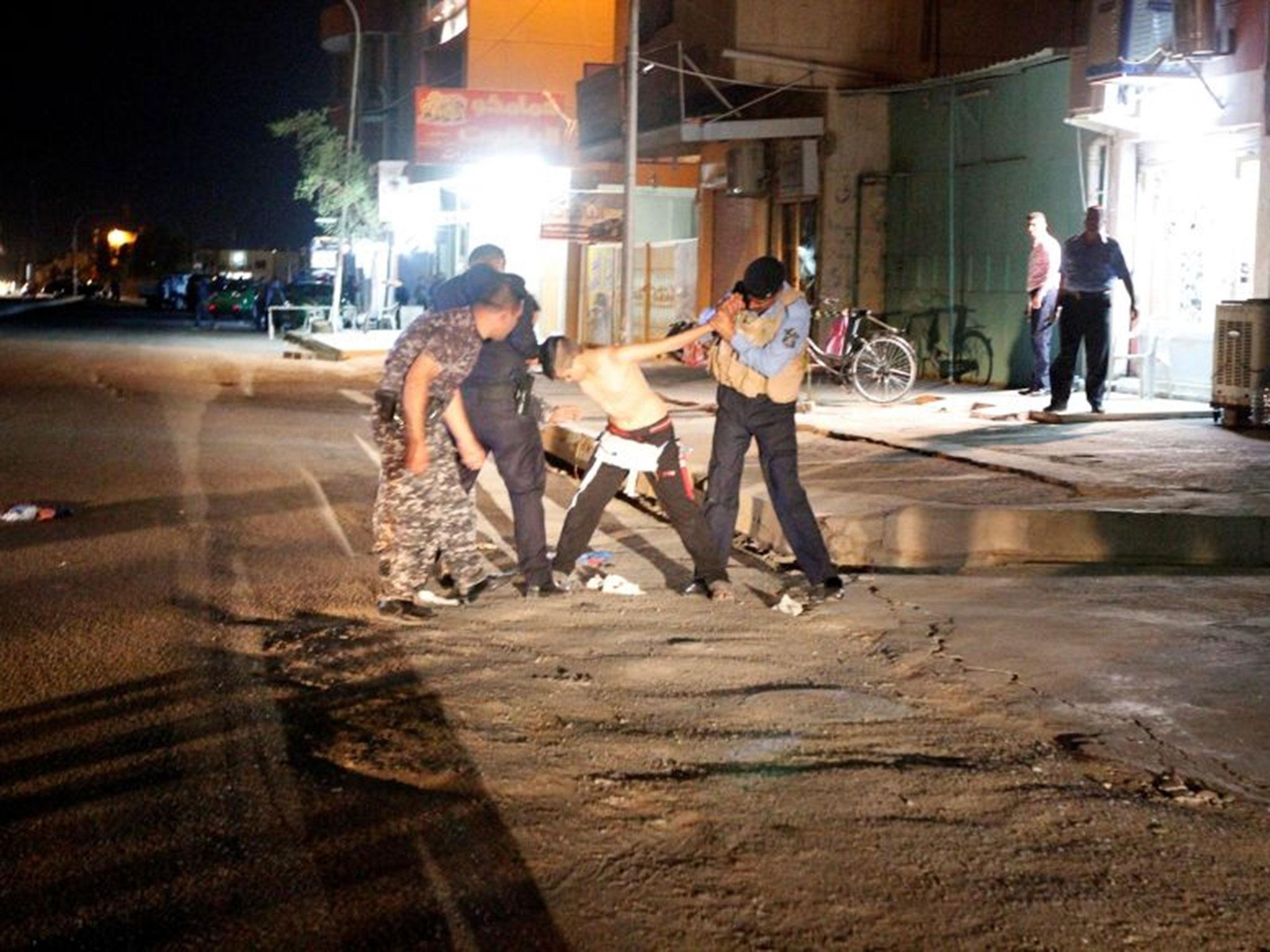 Iraqi security forces remove a suicide vest from a boy in Kirkuk, Iraq, 21 August, 2016.