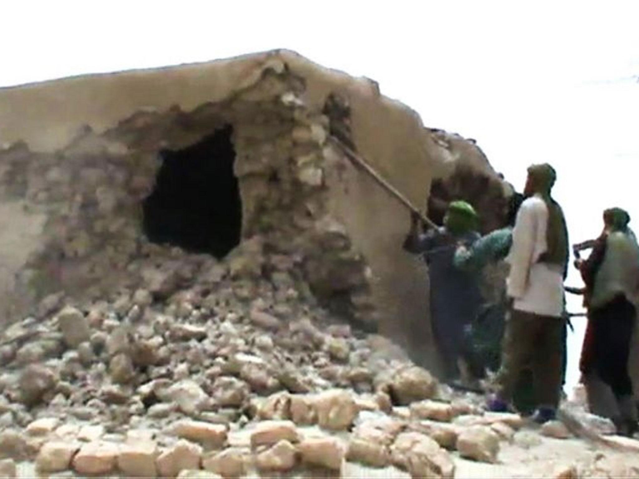 This file image grab photo taken on 1 July, 2012 shows Islamist militants destroying an ancient shrine in Timbuktu