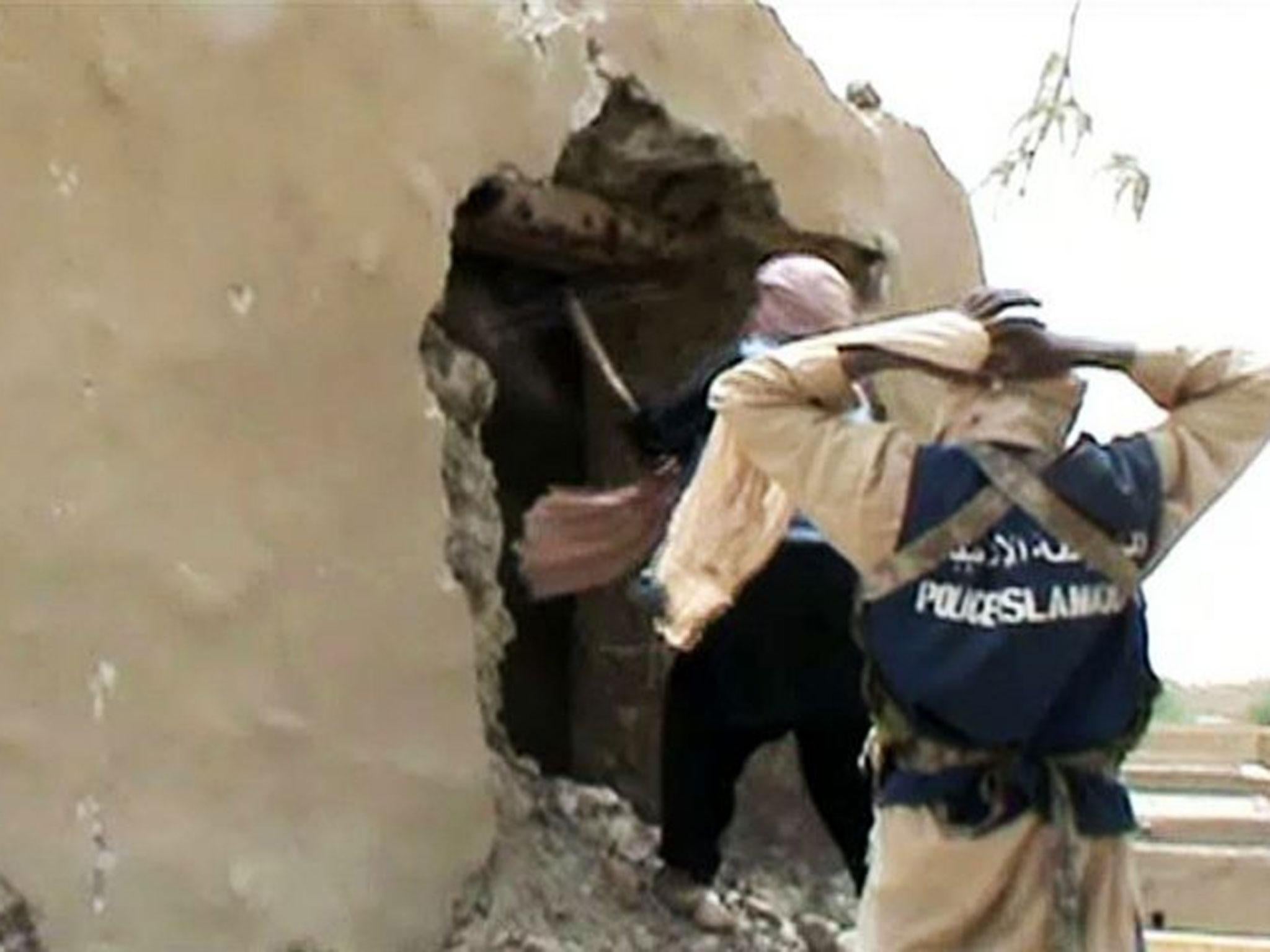 This file image grab photo taken on 1 July, 2012 shows Islamist militants destroying an ancient shrine in Timbuktu