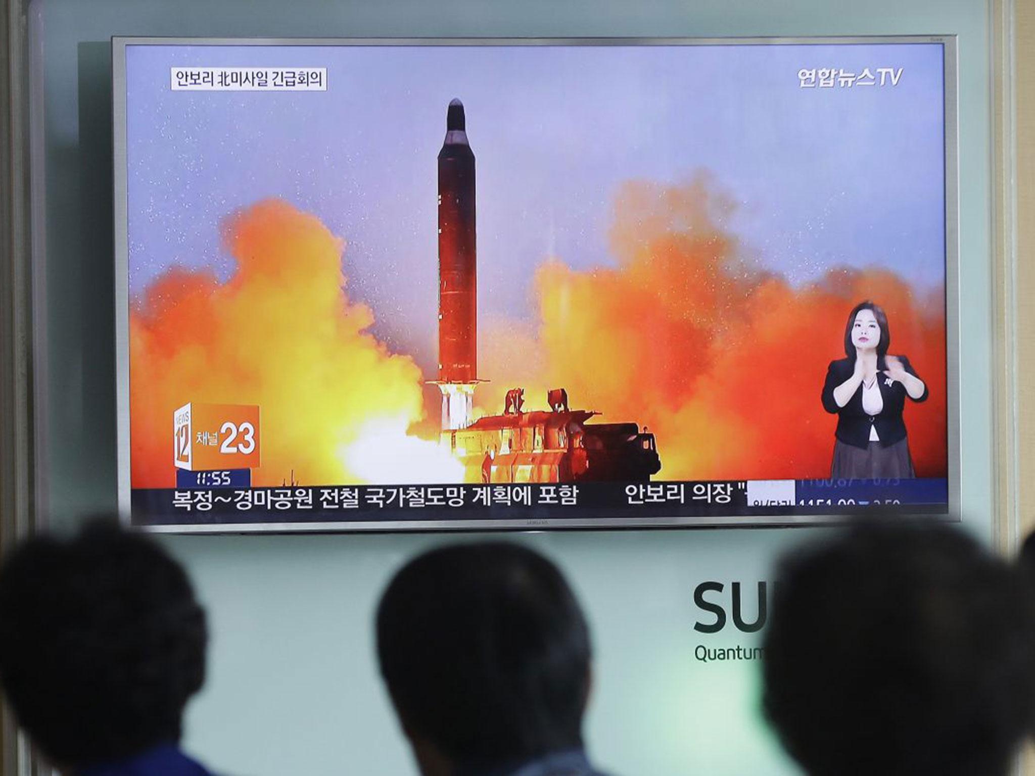 People watch a TV news channel airing an image of North Korea's ballistic missile launch in June. North Korea has made nuclear threats before