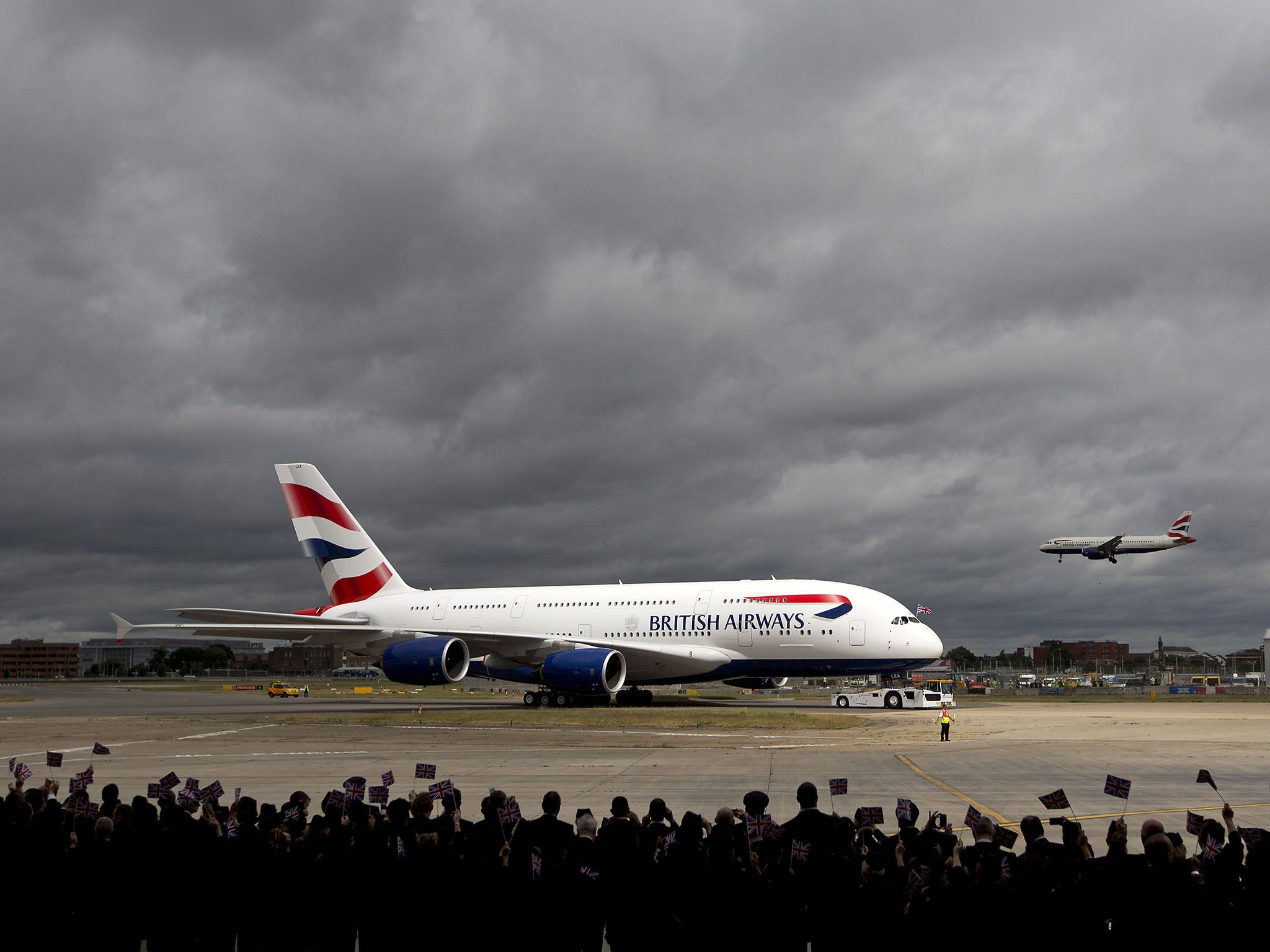 Airline staff wave flags at the arrival of a British Airways Airbus A380 at Heathrow in 2013
