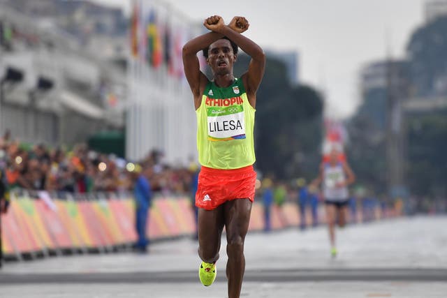 Ethiopia's Feyisa Lilesa (silver) crosses the finish line of the Men's Marathon athletics event at the Rio 2016 Olympic Games, 21 August 2016