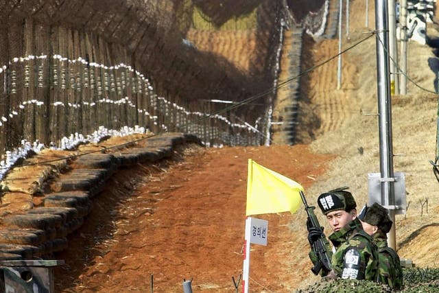 Soldiers from the South man their post along the barbed wire fence inside the DMZ that divides the two Koreas